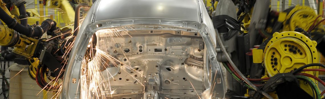 Image of steel body structures being welded in an automotive plant assembly line